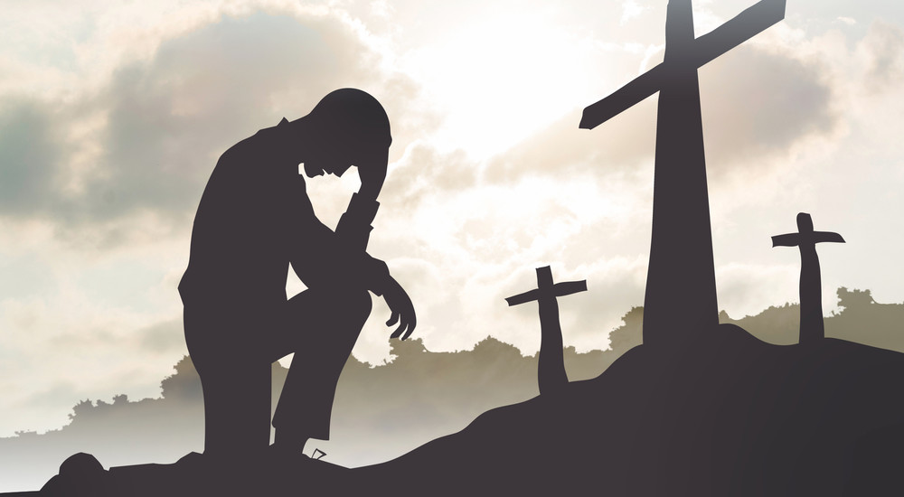 mand som bøjer sig for korset