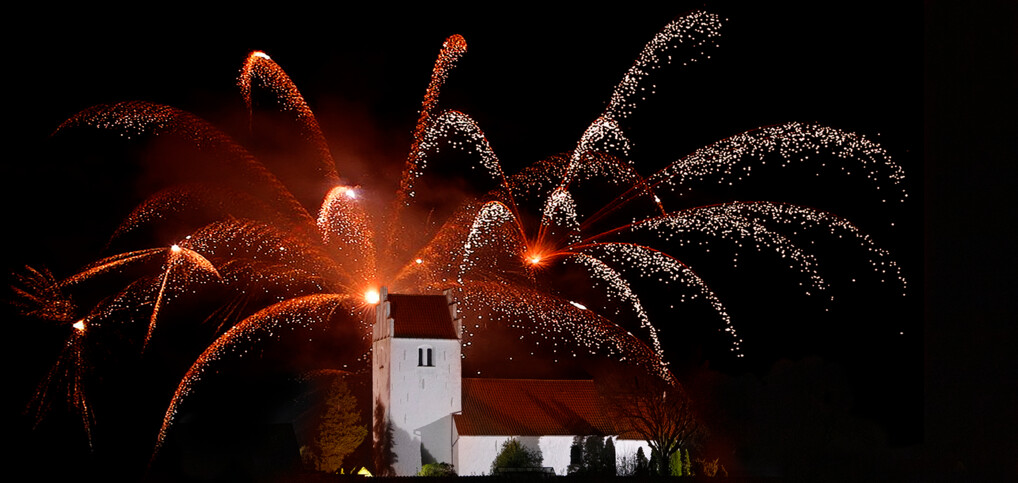 Fyrværkeri over landsbykirke.