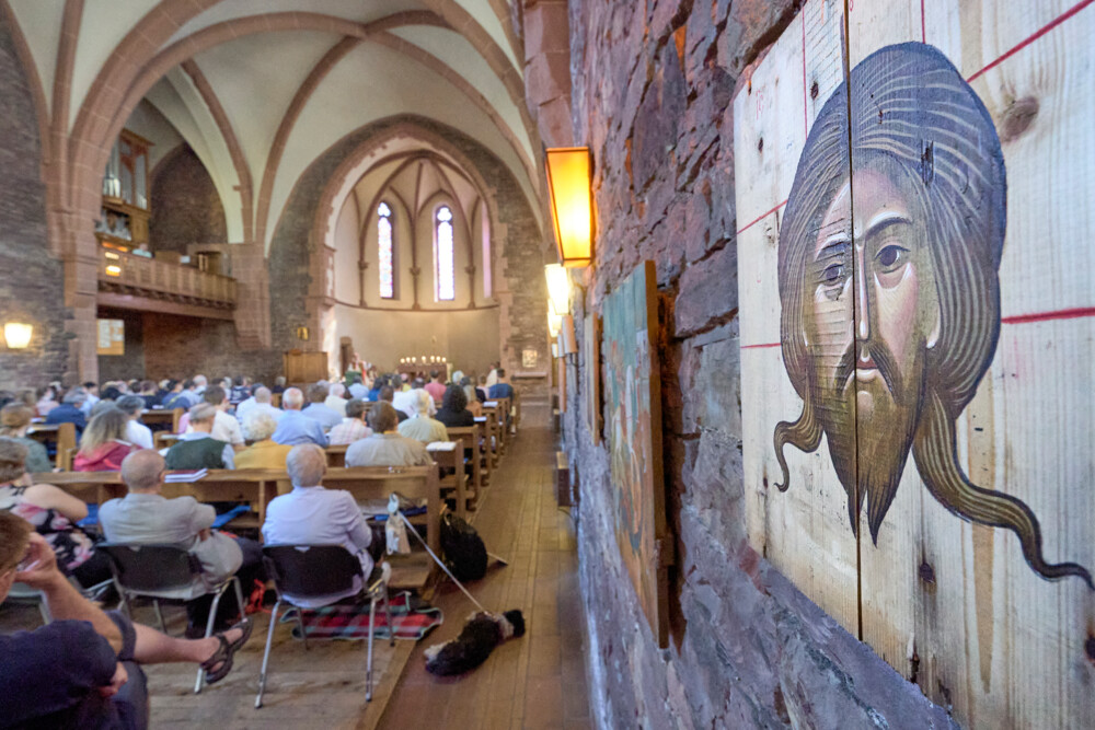 Kirkeforsamling. I fokus er et billede af Jesus Kristus